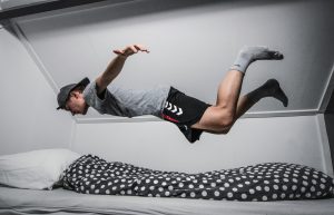 Smart gadgets for Smart Sleep, picture of a guy Falling Asleep/ Flying through air into bed
