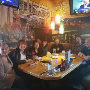 7 members of the Bellevue branch of ITsoft seated around a large dining table.