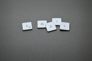 The letters "e", "m", "a", "i", "l" placed on individual white tiles spelling out the word email on a gray-tone background.